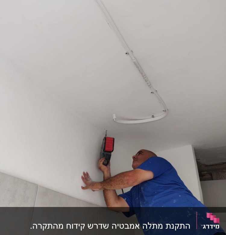 אדם קודח בתקרה עם מקדחה חשמלית